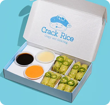Crack Rice takeout box with six green Signature Crack Rice rolls and three sauces