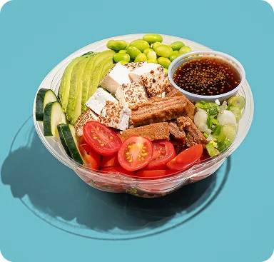 Vegan poke bowl with avocado, tofu, edamame, cherry tomatoes and dressing