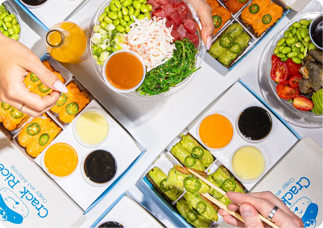 Poke Bowl catering spread with assorted bowls, sauces and hands serving