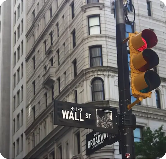 Wall St street sign and red traffic light at Broadway intersection