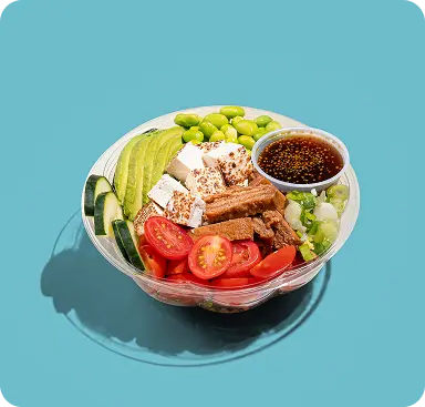 Salad bowl with avocado, edamame, tofu, tomatoes, cucumber and dressing