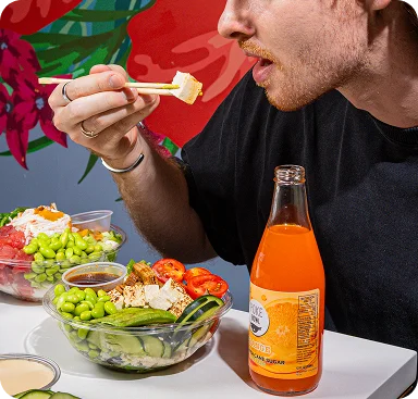 Customer eating a build-your-own poke bowl with chopsticks at Poke Bowl NY, 11 Park Place